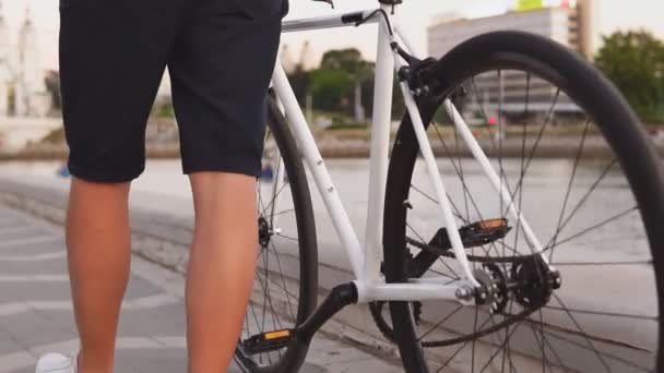 Close up de homem montando uma bicicleta branca na rua. Movimento lento — Vídeo de Stock