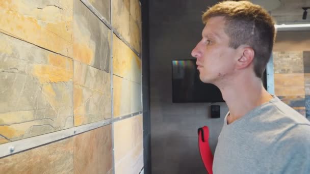 Клиент выбирает плитку из натурального камня в мебельном магазине — стоковое видео