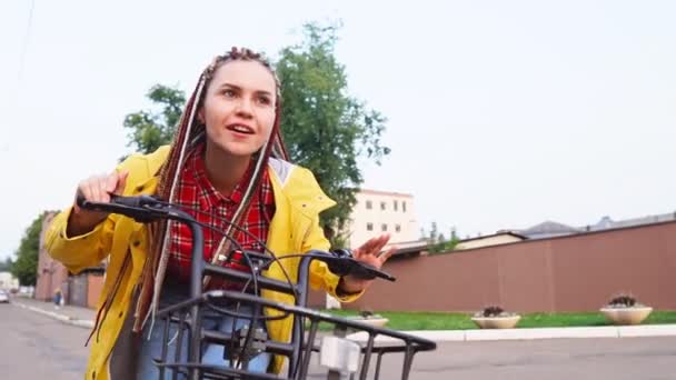 Close up de menina elegante jovem com dreadlocks andar de bicicleta retro amarela — Vídeo de Stock