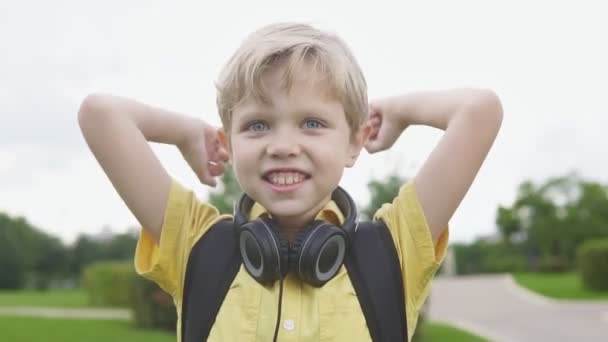 Niño feliz y emocionado con los brazos levantados victoria. Niño rubio afortunado celebra nuevo éxito — Vídeos de Stock