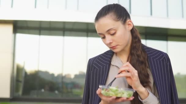 Jonge zakenvrouw salade eten op lunchpauze — Stockvideo