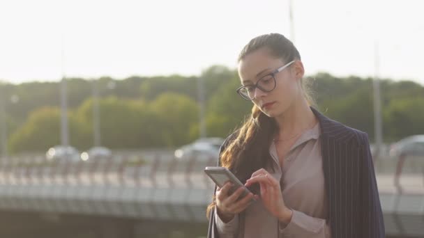 Portret pewności bizneswoman z okularami za pomocą inteligentnego telefonu, przestrzeń kopiowania — Wideo stockowe