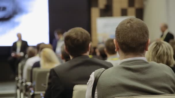 De persoon ziet eruit als de spreker vertelt de toespraak op de conferentie — Stockvideo