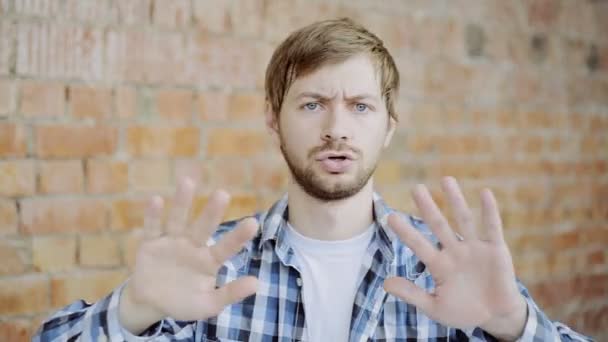 Portrait de jeune homme essayant d'éviter l'offre, dégoût, geste de rejet, signe de désaccord — Video