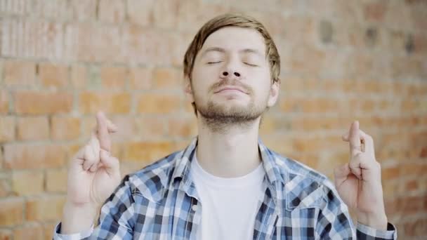 Junger Mann drückt die Daumen, drückt die Daumen, symbolisiert das Glück — Stockvideo