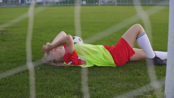 En trött fotbollsspelare tar vila efter matchen. — Stockvideo