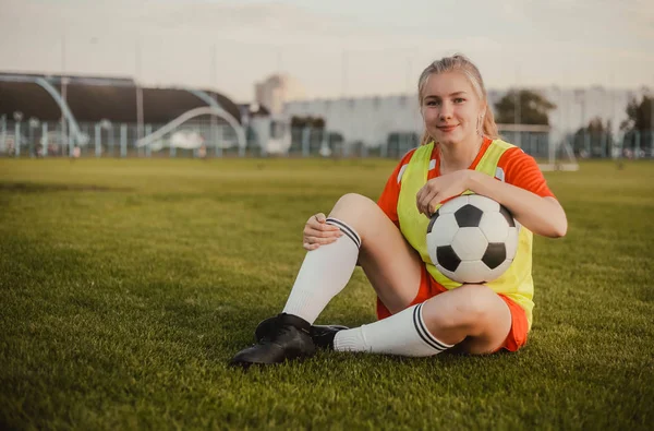 Retrato de adolescente jogador de futebol com bola de futebol sentado na grama, espaço de cópia — Fotografia de Stock