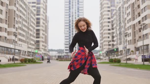 Молодая девушка танцует современный афро-танец на улице — стоковое видео