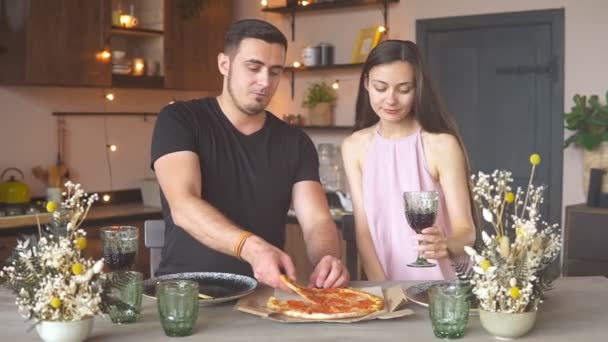Evde pizza ve kırmızı şarapla randevusu olan genç bir çift. — Stok video