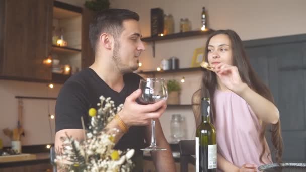 Счастливая пара ест суши и пьет красное вино во время романтического ужина — стоковое видео