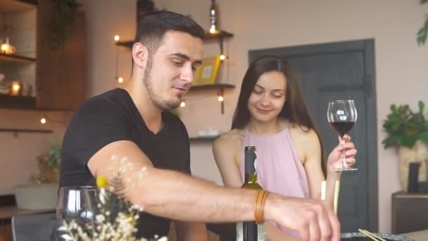 Glückliches leidenschaftliches Paar isst zu Hause Sushi und trinkt Rotwein aus Gläsern — Stockvideo