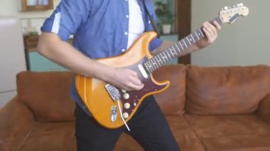 Mutlu sakallı hippi adam elektro gitar çalıyor.