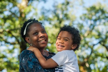Afrikalı anne mutlu bir şekilde çocuğunu kucaklıyor. Harika kopyalama alanı.