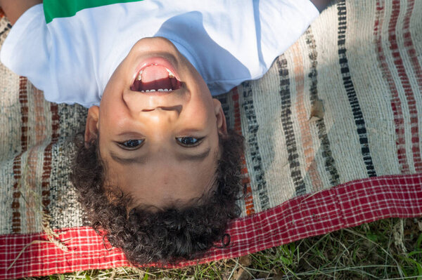 Happy african boy upside down smiling and looking at the camera.