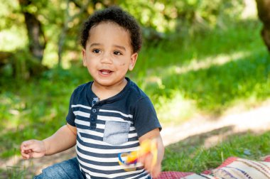 Afrikalı çocuk çimlerin üzerinde oturuyor..