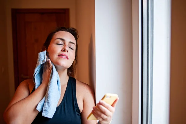 Mujer Talla Grande Limpiando Sudor Con Una Toalla Sosteniendo Teléfono Fotos De Stock Sin Royalties Gratis