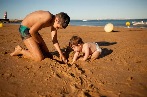 Vista Del Perfil Niño Mayor Jugando Playa Con Hermanito Pequeño Imagen De Stock