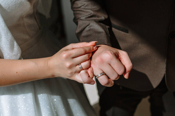 The hands of the newlyweds, which wearing a wedding ring, close-up