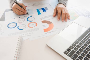 İş kadını, elindeki belgeleri analiz eder. Not defterindeki grafikler ve diyagramlar. Finansal ve yatırım kavramı..