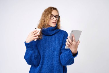 Cep telefonu ve beyaz arka plan üzerinde elinde tablet ile sarışın kız öğrenci