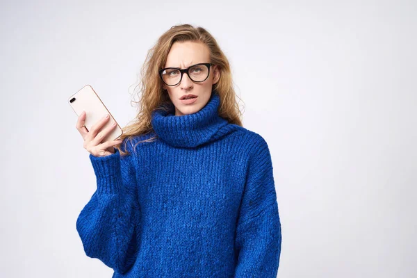 kız sarışın kaşlarını çattı, kameraya el ile hareket eden bir telefon arıyorum memnun