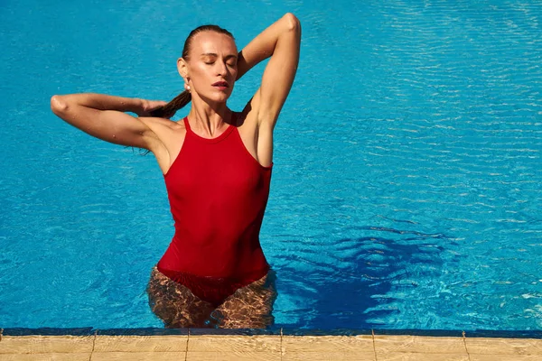 Mädchen im roten Badeanzug im Pool — Stockfoto