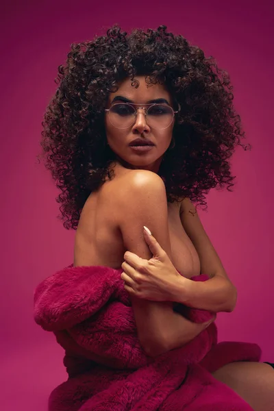 parlak bir arka planda bir kürk ceket yarım çıplak model portre