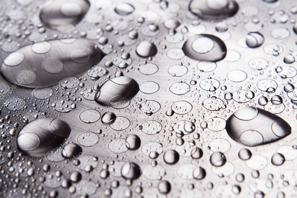 The water drops on the metal surface close up