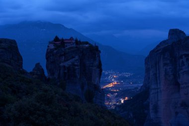 Manastır Kutsal Üçleme, Meteora, Yunanistan. UNESCO Dünya Mirası Sitesi. Uçurumun kenarında tapınağı olan destansı manzara gece boyunca dramatik gökyüzü arka planında.