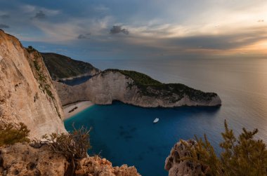 Günbatımında gemi enkaz sahili ve Navagio körfezi. İyon Denizi 'ndeki Yunan adası Zakynthos' un en ünlü doğal simgesi..