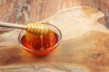 Ballı abur cubur ve ballı cam kase. Yakın plan. Sağlıklı organik gıda konsepti. Kahverengi ahşap arka plan.