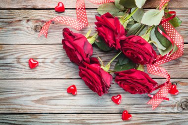 Ahşap rustik arka plan üzerinde kırmızı gül buketi.