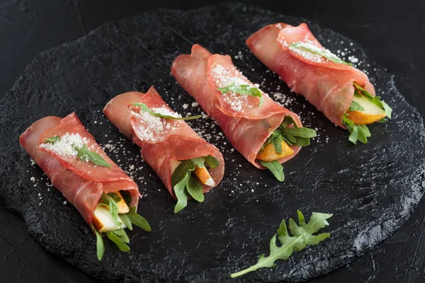 Rollos de jamón sobre pizarra negra . — Foto de Stock