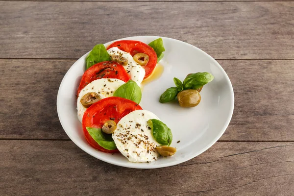 Lahodný Čerstvý Caprese Salát Zralými Rajčaty Sýrem Mozzarella Čerstvými Listy — Stock fotografie