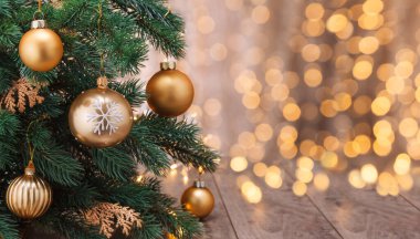 Noel gecesi baloları, arka plandaki Noel ışıklarına karşı Cristmass ağacında asılı. Çelenkli yeni yıl altın madalyaları.