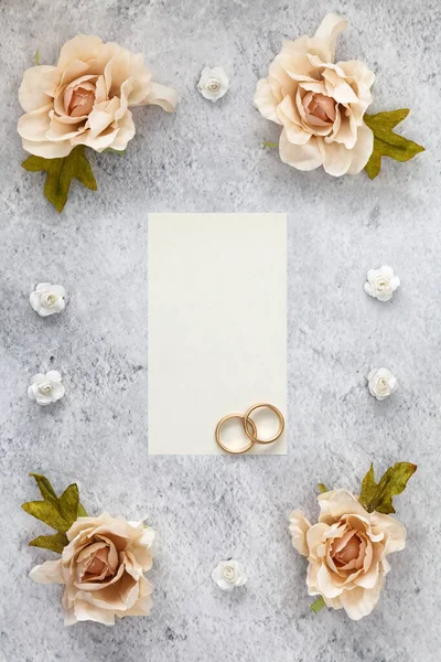 用玫瑰装饰的桌上摆放着婚礼请柬纸 — 图库照片