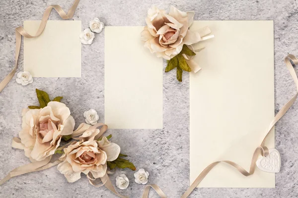 Wedding invitation cards papers laying on table decorated with roses