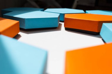 Beyaz arkaplanda güzel mavi, turuncu ve pembe altıgen kutular var. Mesaj için yer. Boş merkez. yan görünüm