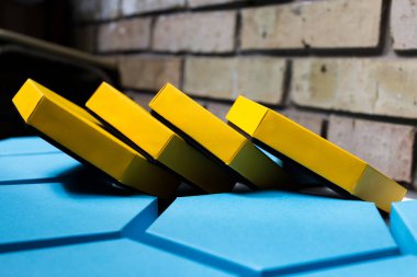 Güzel mavi ve sarı altıgen kutular, tuğla arka planda mevcut. Mesaj için yer. Yan görünüş. Model