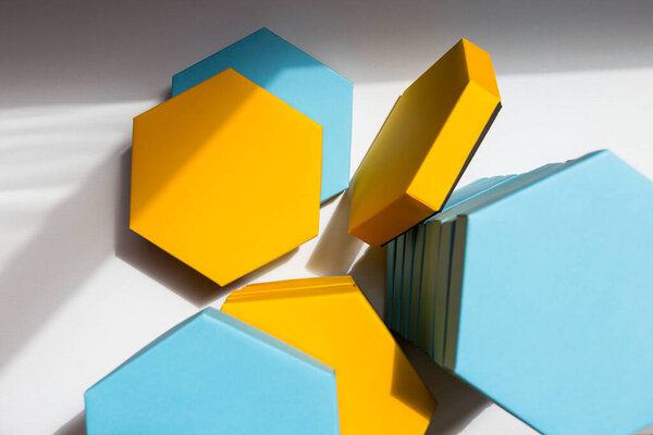 A close up beautiful blue and yellow hexagon boxes of present on the white background. Place for text. Empty centre. Top view. Flat lay. Mockup