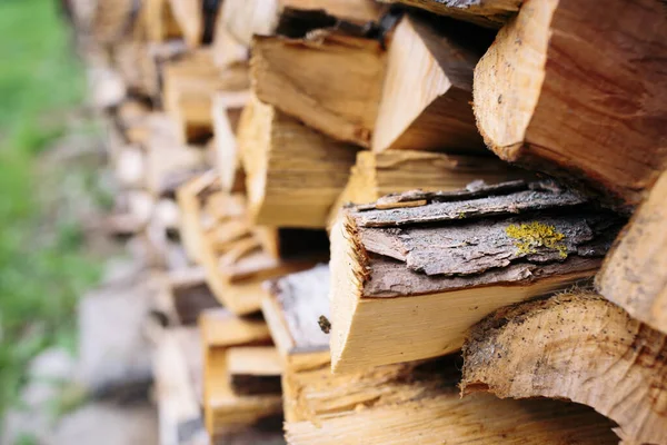 Closeup photo of many firewood evenly stacked against the yard. Dry wood logs. Beautiful texture. — Stock Photo, Image