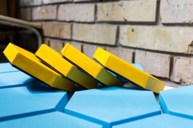 Güzel mavi ve sarı altıgen kutular, tuğla arka planda mevcut. Mesaj için yer. Yan görünüş. Model