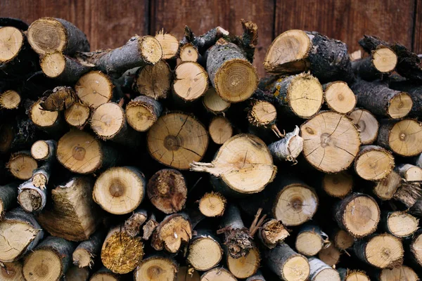 Closeup photo of many firewood evenly stacked against the wall. Dry wood logs. Beautiful texture. — Stock Photo, Image