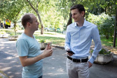 Sokakta iki adam güzelce konuşur. Bir Amerikalı ve bir Avrupalı. İki meslektaşım şehirde tanıştı. Tanıdık..