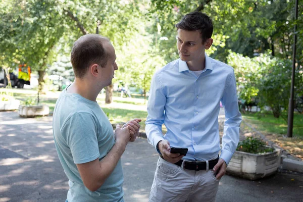 Sokakta iki adam güzelce konuşur. Bir Amerikalı ve bir Avrupalı. İki meslektaşım şehirde tanıştı. Tanıdık..