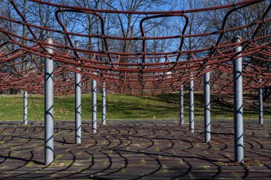 Gri bir sonbahar gününde parktaki çocuklar için açık hava oyun alanı, ip tırmanma malzemeleri.