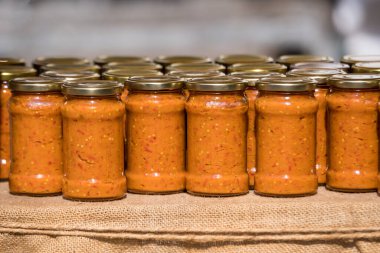 Yeni ev yapımı zakuska ile sıralanmış cam kavanozlar. Domatesler, soğanlar ve patlıcanlar gibi sebzelerden yapılan geleneksel Balkan ve Doğu Avrupa yemekleri. Sağlıklı vegan gıdalara yakın.