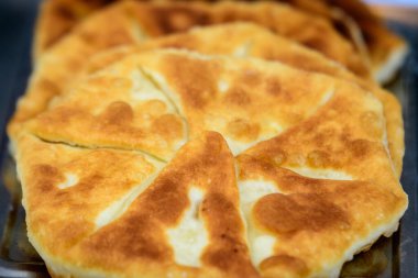 Taze pişirilmiş geleneksel peynir ve etli turta, hafta sonu sokak yemekleri pazarında satışa sunuldu.