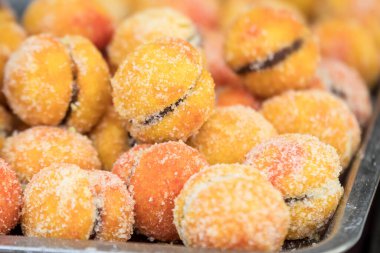 Büyük bir porsiyon taze pişmiş şeftali keki sokak yiyecekleri pazarında, yan manzaralı bir masada sergileniyor.