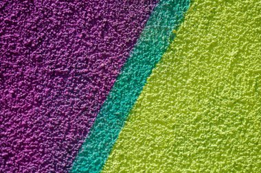 Rengi parlak mor, sarı ve yeşil renklerle boyanmış duvar resimleri gibi minimalist desenli arka plan.